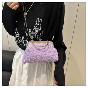 Nahaufnahme der violetten 3D-Stoffrosenblüten und der goldenen Metallkette der Handtasche