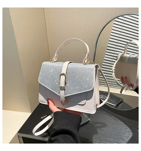 Detail der weißen Handtasche mit glitzernder Klappe und goldener Schnalle für Damen