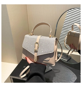 Detail der beige Handtasche mit glitzernden Strasssteinen und goldener Metallschließe
