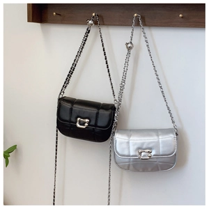 Close-up of quilted saddle bags in black and silver with C-shaped interlocking buckles