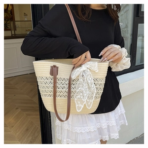 Detail der gewebten Strohtasche mit Mesh-Muster, Lederriemen und Spitzen-Schleife