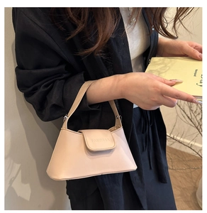 Détail du sac en cuir crème avec logo FANYISSA embossé et texture de cuir raffinée