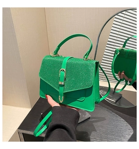 Detailaufnahme der hellgrünen Pailletten-Handtasche mit Metallschnalle und Schultergurt