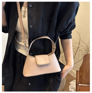 Détail d'un sac à main minimaliste en cuir beige avec logo embossé et poignée