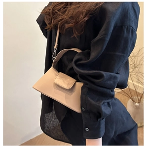 Detail of beige faux leather handbag with embossed FANYIGGA logo and silver hardware