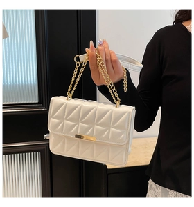Détail du sac à bandoulière blanc matelassé avec texture gaufrée et boucle en métal doré