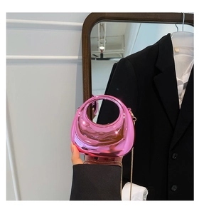 Detail of metallic pink half-moon chain bag showing mirror finish and mini size