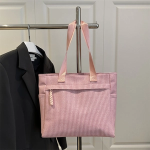 Pink woven tote bag with large capacity and multi-pocket design on display stand