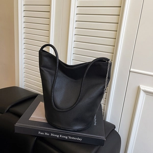 Minimalist black leather bucket bag with silver chain and unique ring handle