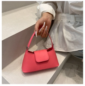 Detail of a bright pink handbag featuring embossed logo and premium silver hardware