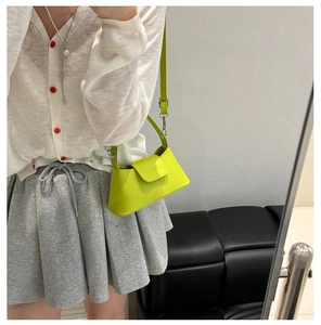 Détail du sac sous le bras en cuir vert néon avec bandoulière réglable et poignée