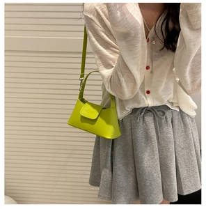 Detail of lime green mini leather flap bag with embossed logo and adjustable shoulder strap