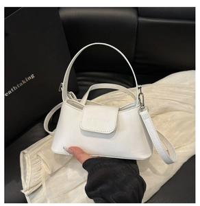 Close-up of white leather underarm bag featuring silver hardware and a logo detail