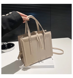 Détail d'un cabas en cuir beige avec des accents de cordon modernes et une longue bandoulière
