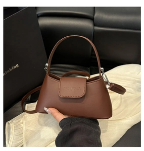 Detail of dark brown leather handbag with flap closure and branded fanyissa lettering