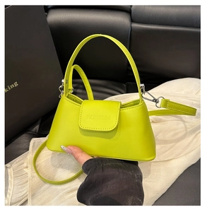 Detail of neon green PU leather handbag featuring a brand logo and silver metal clasp