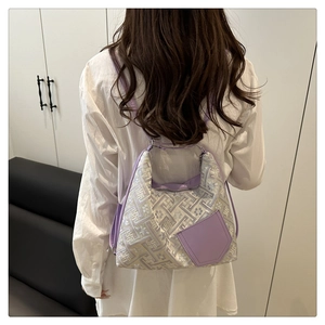 Dettaglio del tessuto jacquard viola con motivi floreali e spalline in pelle