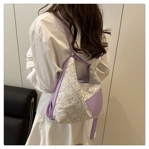 Detail view of lavender floral jacquard shoulder bag with leather strap on a female model