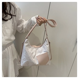 Detail of white jacquard fabric with geometric patterns and pink leather strap on handbag