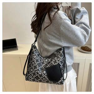 Detail of vintage black and white geometric pattern tote bag worn over the shoulder