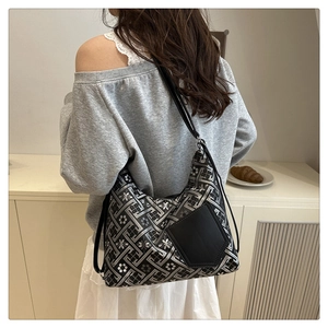 Sac hobo chic à motif géométrique et bandoulière en cuir noir porté par un mannequin