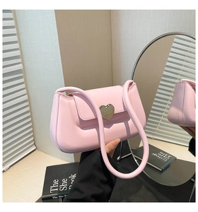 Détail du sac à main rose élégant avec fermoir métallique en forme de cœur et texture lisse