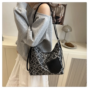 Detail of embroidered geometric patterns and black leather pocket on a chic shoulder bag