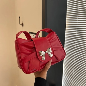 Chic red faux leather underarm bag with bow detail and silver metal buckle