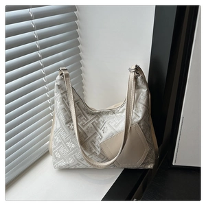 Détail du tissu jacquard floral et patch en cuir sur un sac à bandoulière minimaliste