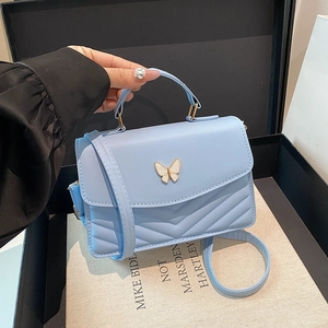Chic light blue quilted crossbody bag with golden butterfly buckle and top handle strap