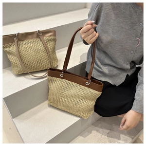 Detail of woven straw tote bags with leather straps in light and dark brown finishes
