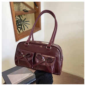 Macro detail of wine red PU leather bag with bow pockets and silver zippers