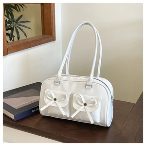 Detail of white balletcore shoulder bag featuring decorative bows and double front pockets