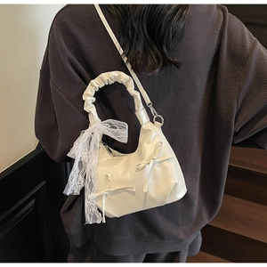 Détail d'un sac à main blanc crème style ballet avec nœud et ruban en dentelle élégant