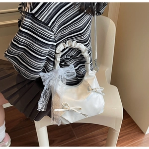 Détail du sac à main blanc style ballet avec nœuds et poignée à volants
