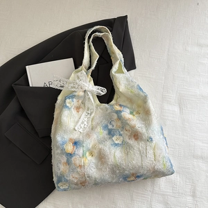 Detail of floral jacquard tote bag with white lace bow on minimalist white background
