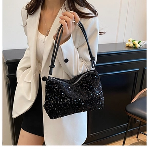 Close-up of black sequined shoulder bag featuring metallic zipper and leather knot detail