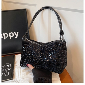 Close-up of black sequined shoulder bag with textured sequins and knot-style strap detail