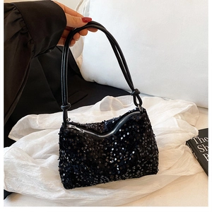 Close-up of black sequined shoulder bag with textured finish and silver zipper detail