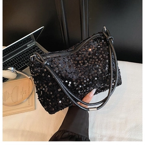 Detail of a chic black sequined baguette bag showing shimmering texture and shoulder strap