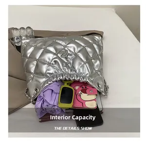 Internal capacity of silver quilted tote bag showing umbrella, wallet, and phone