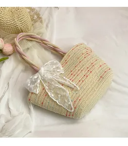 Close-up of woven straw tote bag with colorful texture and decorative white lace bow
