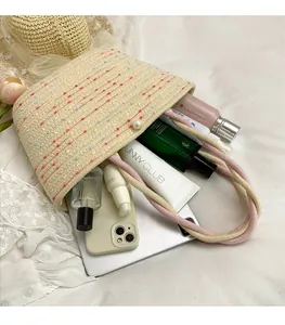 Detail of hand-woven beige basket bag showing spacious interior with pearl clasp