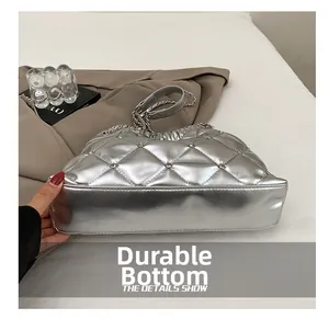Detail view of the wear-resistant bottom and silver quilted fabric on the shoulder bag