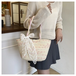 Detail of woven straw bag with colorful polka dots, pearl clasp, and white lace bow