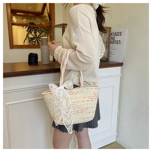 Detail of woven tote bag with white lace bow decoration and premium pearl button closure