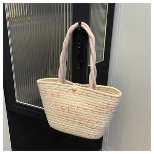 Detail of beige woven cotton tote bag with colorful polka dots and pearl button closure