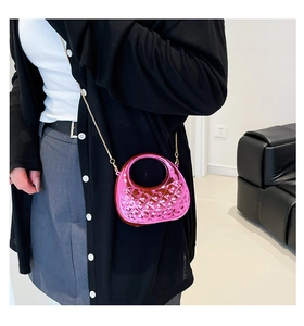 Macro detail of glossy fuchsia diamond lattice box bag with elegant gold chain strap