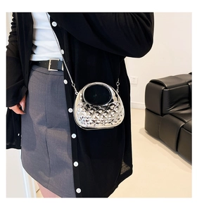Close-up of silver geometric textured mini bag with metallic chain and handle detail