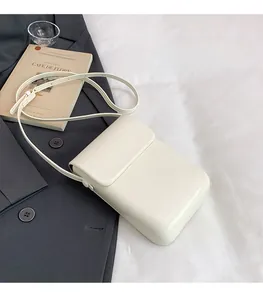 Minimalist cream vertical phone bag with smooth leather texture and crossbody strap detail